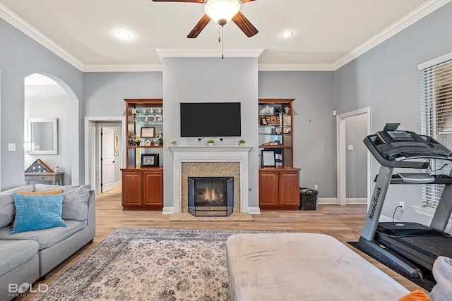 living room with crown molding, light hardwood / wood-style floors, and ceiling fan