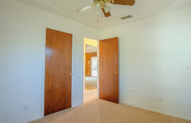 unfurnished bedroom with ceiling fan, a closet, and light carpet