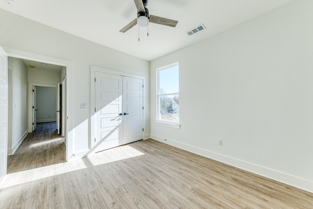 unfurnished bedroom with light hardwood / wood-style flooring, a closet, and ceiling fan