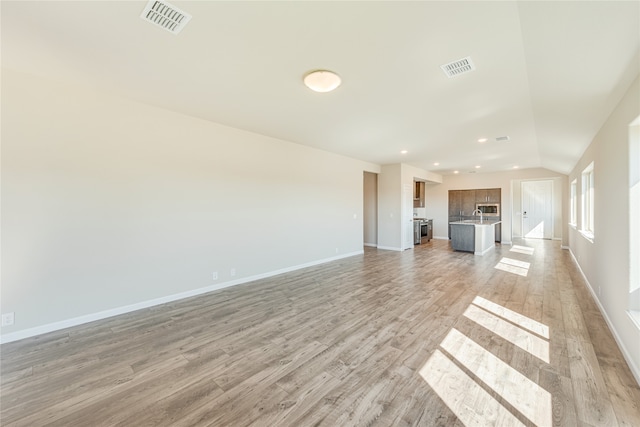 unfurnished living room featuring light hardwood / wood-style flooring and vaulted ceiling