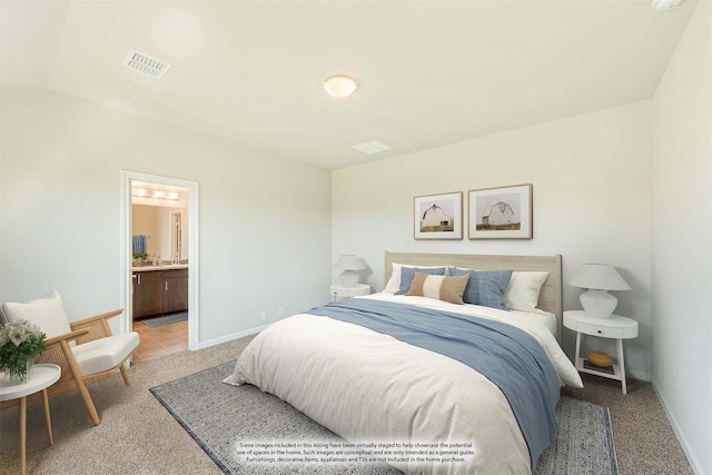 bedroom with connected bathroom, carpet, and vaulted ceiling