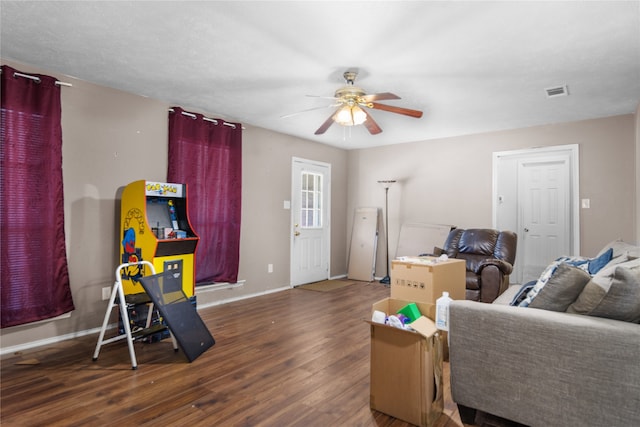 living room with ceiling fan and dark wood-type flooring