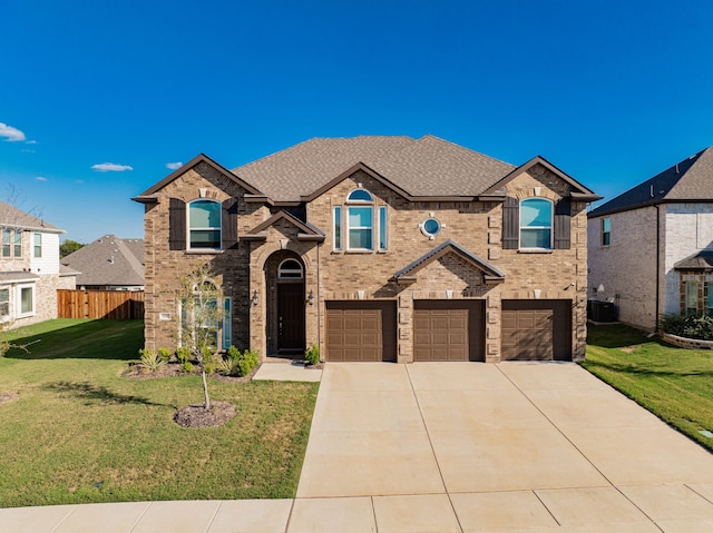 view of front of house featuring a garage, a front yard, and central AC