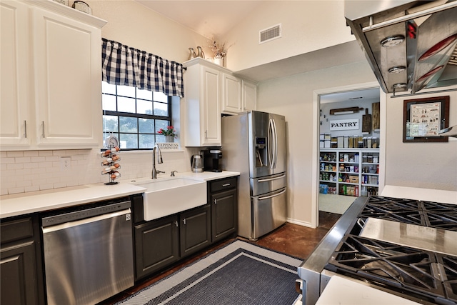 kitchen with white cabinetry, sink, backsplash, lofted ceiling, and appliances with stainless steel finishes