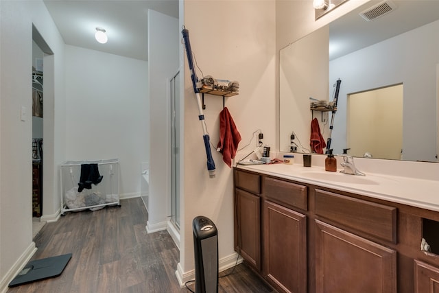 bathroom featuring wood-type flooring, vanity, and a shower with door