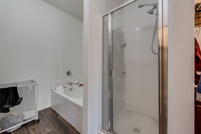 bathroom featuring plus walk in shower and hardwood / wood-style flooring