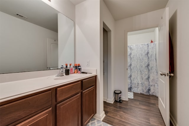 bathroom featuring hardwood / wood-style flooring, vanity, and curtained shower