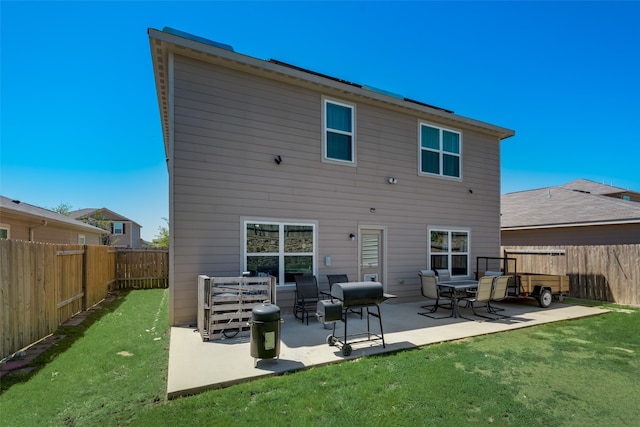 back of property featuring a lawn and a patio area