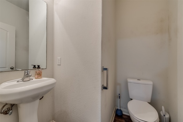 bathroom with hardwood / wood-style flooring and toilet