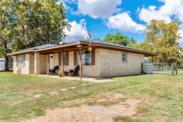 rear view of property with a lawn and a patio area