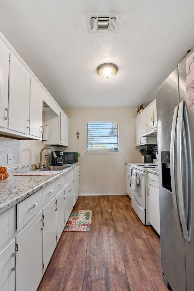 kitchen featuring white electric range oven, sink, dark wood-type flooring, white cabinetry, and stainless steel refrigerator with ice dispenser