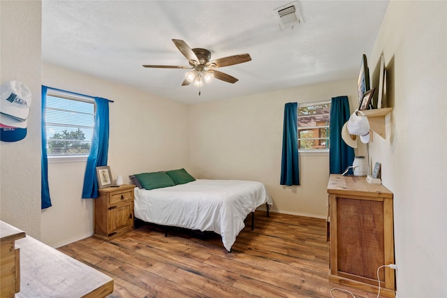 bedroom with wood-type flooring and ceiling fan