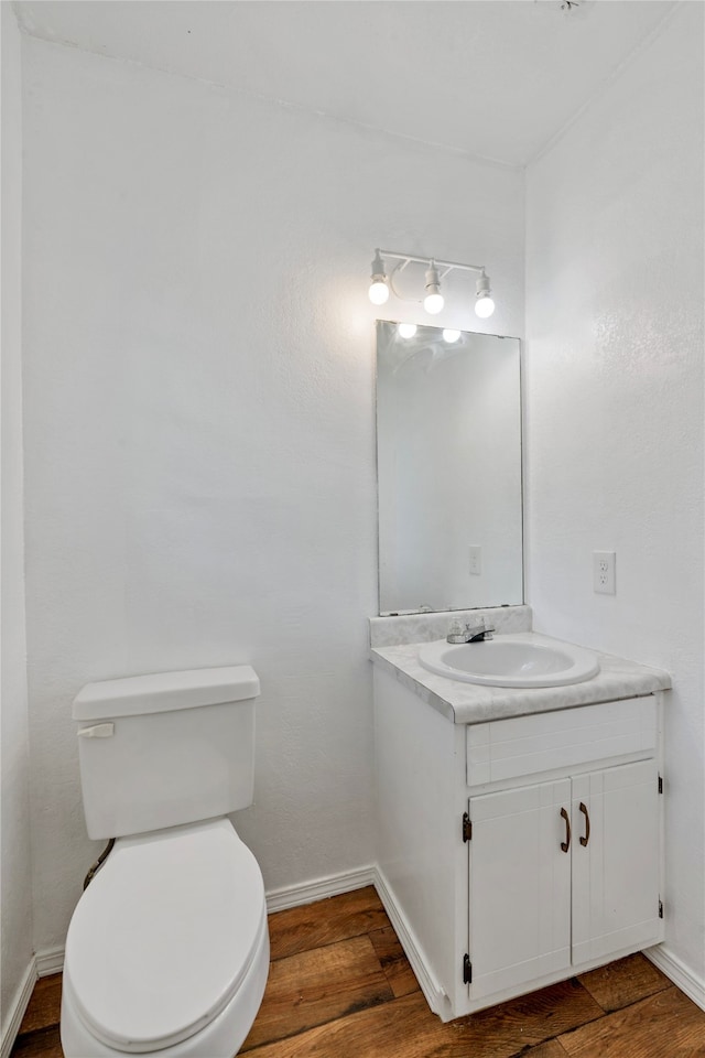 bathroom with vanity, toilet, and hardwood / wood-style flooring