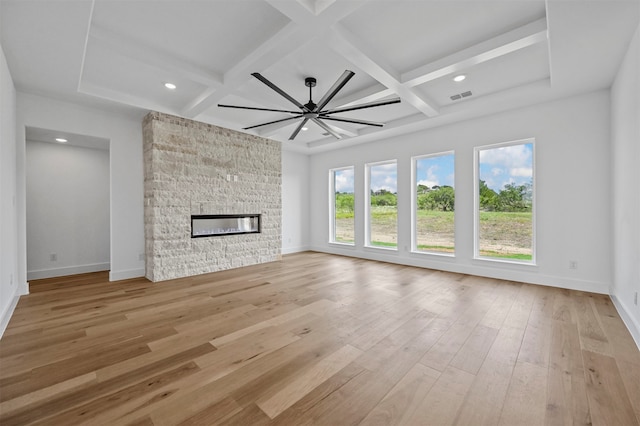 unfurnished living room featuring light hardwood / wood-style floors, coffered ceiling, a fireplace, and ceiling fan