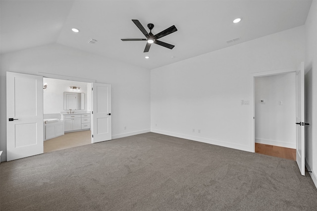 unfurnished bedroom with ceiling fan, lofted ceiling, connected bathroom, and light carpet