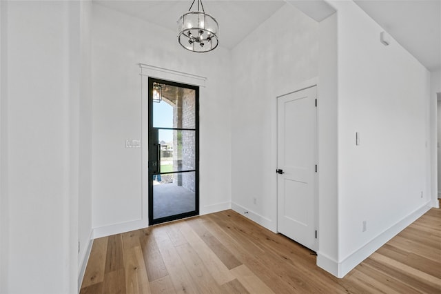 entryway featuring light hardwood / wood-style floors and a chandelier