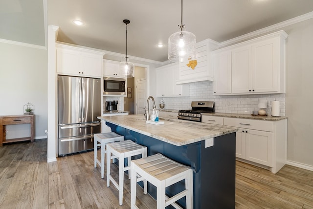 kitchen with white cabinets, baseboards, appliances with stainless steel finishes, decorative backsplash, and a breakfast bar area