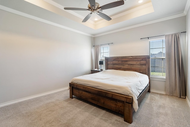 bedroom with a tray ceiling, baseboards, ornamental molding, and carpet floors