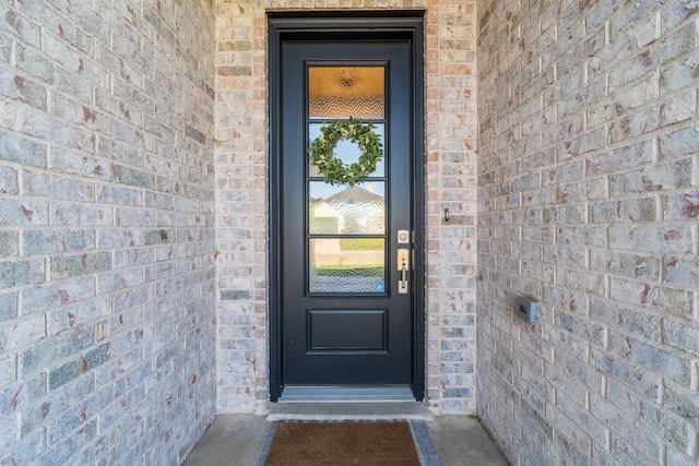 property entrance with stone siding and brick siding