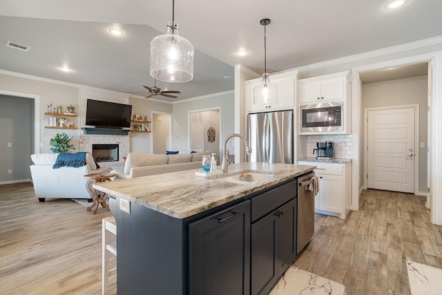 kitchen with stainless steel appliances, visible vents, white cabinetry, and a sink