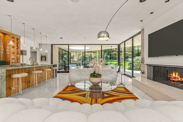 living room with light tile patterned flooring, floor to ceiling windows, and a tile fireplace