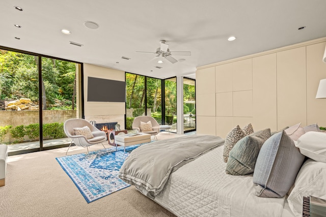 bedroom featuring carpet flooring, ceiling fan, access to outside, and expansive windows