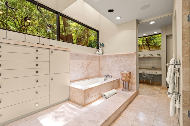 full bathroom with a garden tub, a healthy amount of sunlight, tile patterned flooring, and recessed lighting