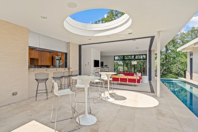 view of patio with outdoor dry bar and an outdoor pool