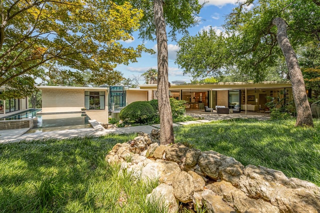 back of house featuring an outdoor pool, a patio, and stucco siding