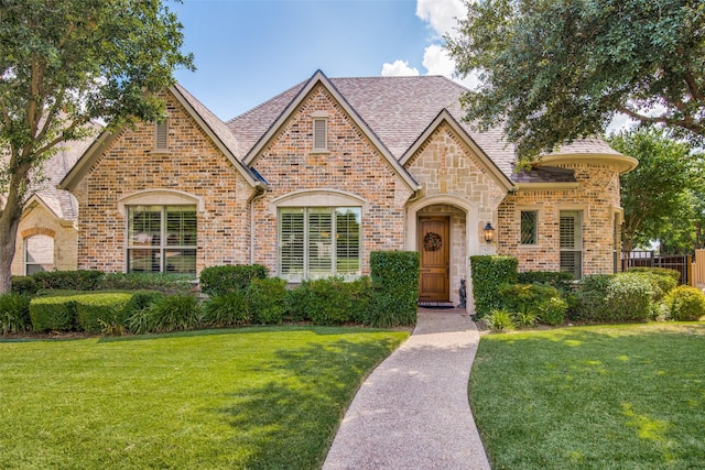 tudor-style house featuring a front yard