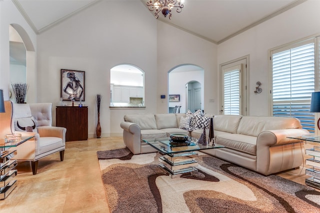 living room featuring ornamental molding, a notable chandelier, and high vaulted ceiling