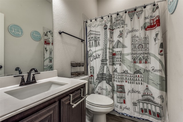 bathroom with a shower with curtain, hardwood / wood-style flooring, vanity, and toilet