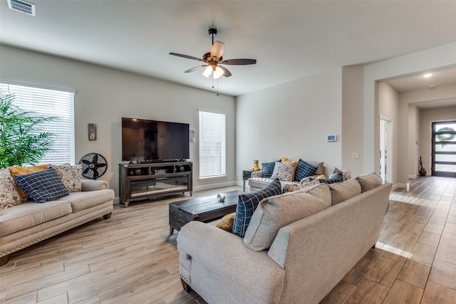 living room with light hardwood / wood-style floors and ceiling fan