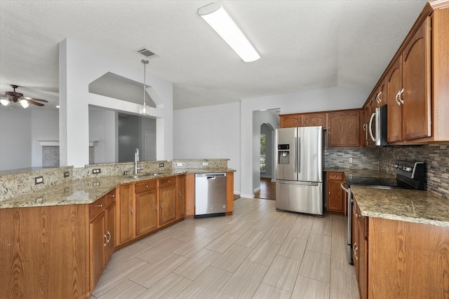 kitchen featuring ceiling fan, a textured ceiling, stainless steel appliances, and sink