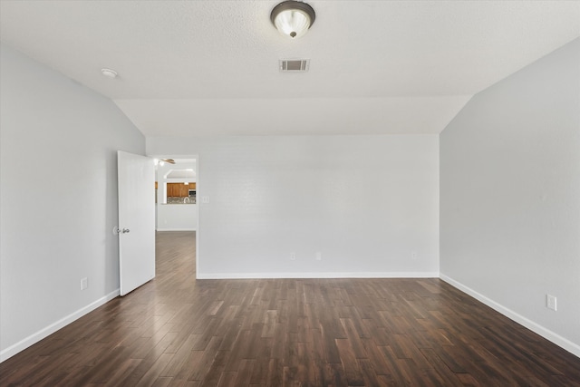 unfurnished room featuring vaulted ceiling and dark wood-type flooring