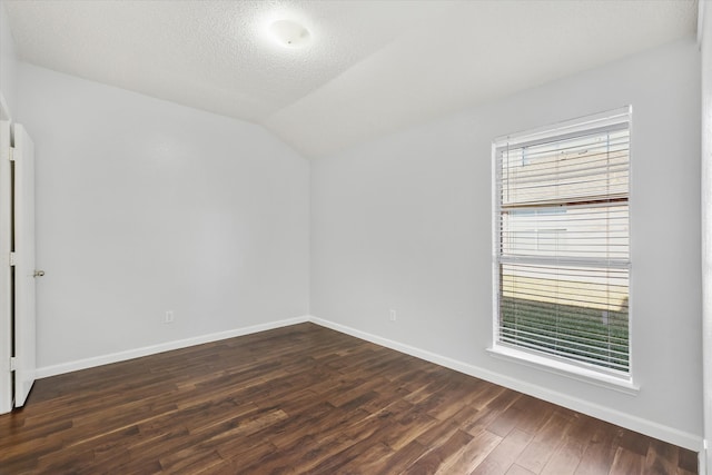 unfurnished room with a textured ceiling, vaulted ceiling, and dark hardwood / wood-style flooring