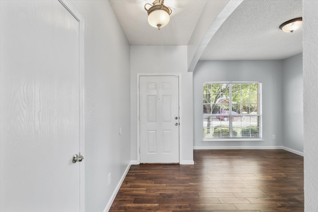 foyer with a textured ceiling and dark wood-type flooring