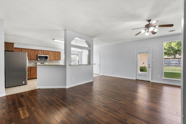 kitchen with wood-type flooring, a textured ceiling, stainless steel appliances, and ceiling fan