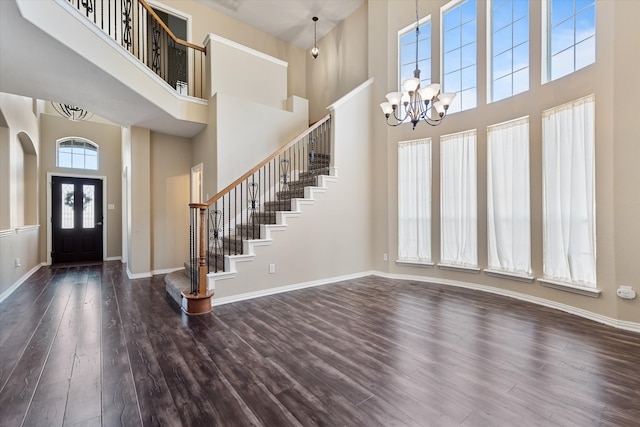 entrance foyer with plenty of natural light, a high ceiling, dark hardwood / wood-style flooring, and a chandelier