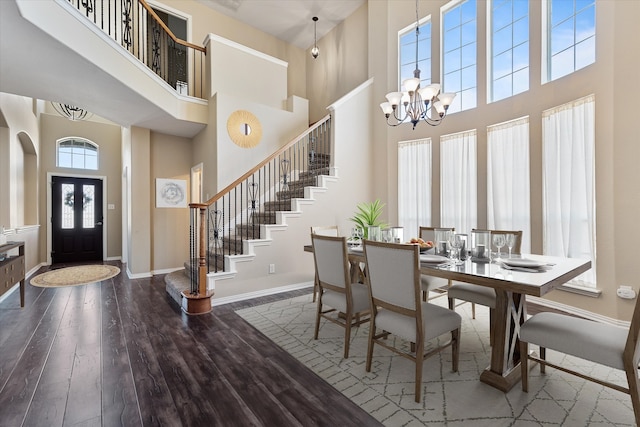 dining space featuring a high ceiling, an inviting chandelier, and hardwood / wood-style flooring