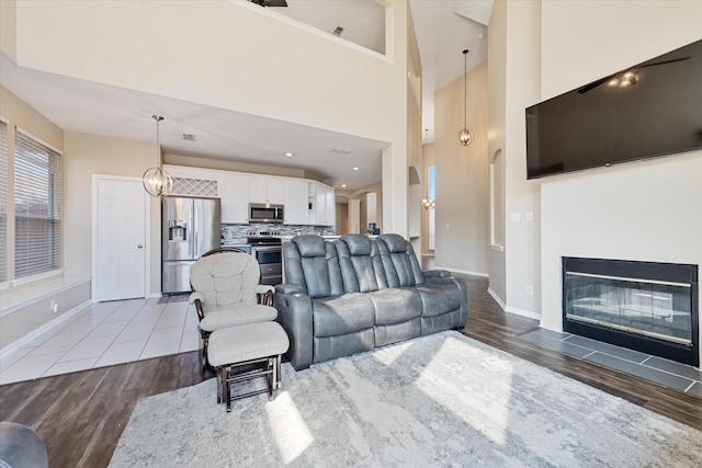 living room featuring a towering ceiling and hardwood / wood-style floors