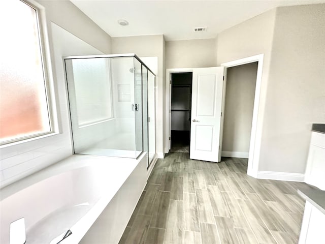 bathroom featuring shower with separate bathtub, vanity, and wood-type flooring