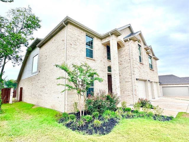 view of side of home featuring a garage and a lawn