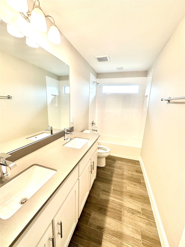 full bathroom featuring wood-type flooring, vanity, tiled shower / bath combo, and toilet