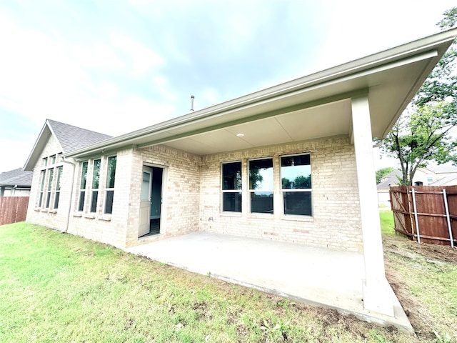 rear view of house with a yard and a patio