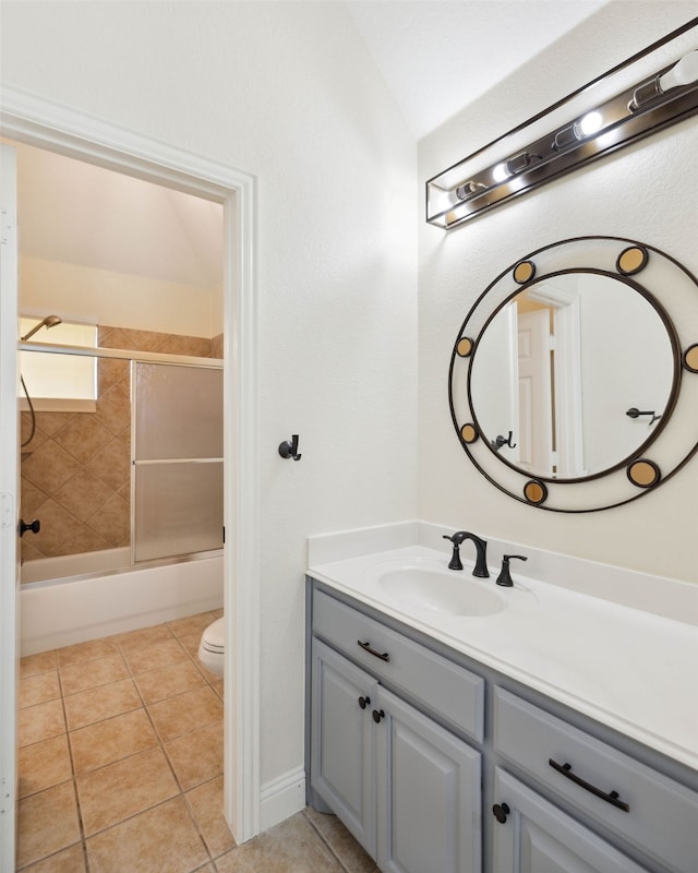 full bathroom with tiled shower / bath, vanity, toilet, and tile patterned floors