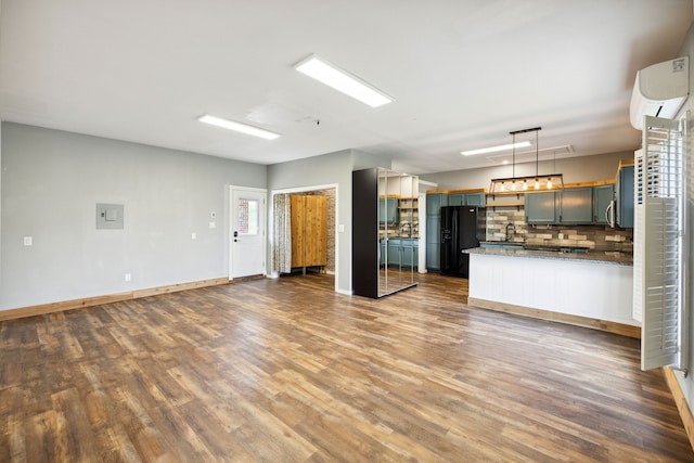 kitchen with black fridge with ice dispenser, hardwood / wood-style floors, tasteful backsplash, and decorative light fixtures