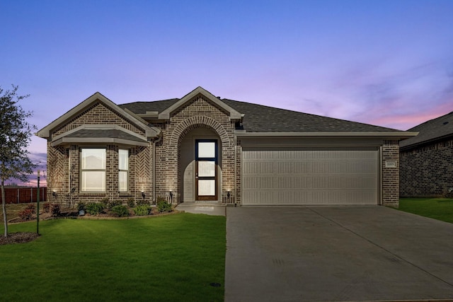 ranch-style house featuring a lawn and a garage