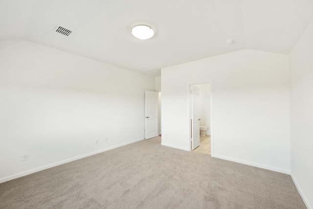 carpeted empty room with lofted ceiling