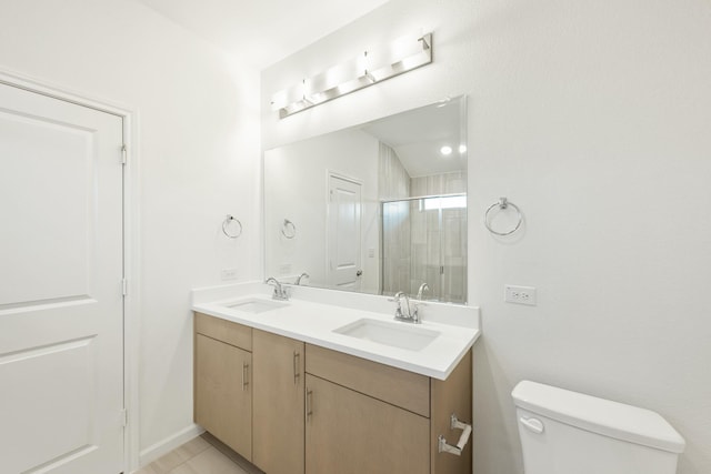 bathroom featuring tile patterned flooring, vanity, toilet, and walk in shower